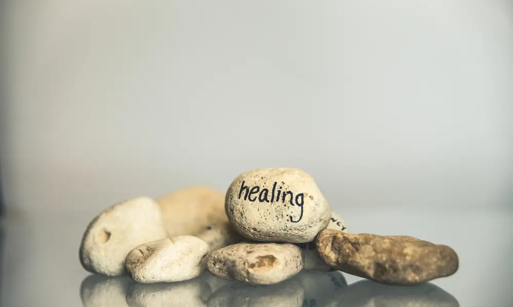 一個石頭推，最上方的石頭上寫著 healing (「醫治」的英文)