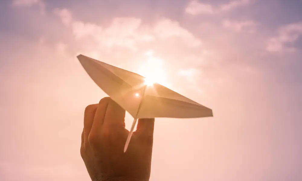 一隻手即將發射一台紙飛機